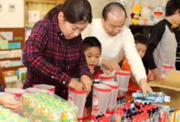 数種類のお菓子、ペンケース、 鉛筆などを詰め合わせていく作業。